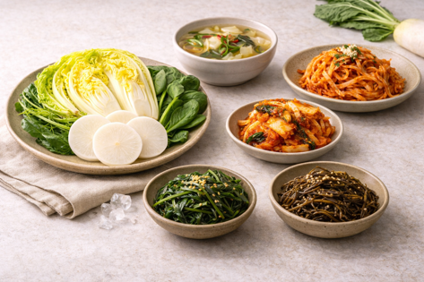 겨울 채소인 배추와 무, 시금치를 중심으로 국, 김치, 나물 반찬을 함께 담은 한식 겨울 식탁 구성